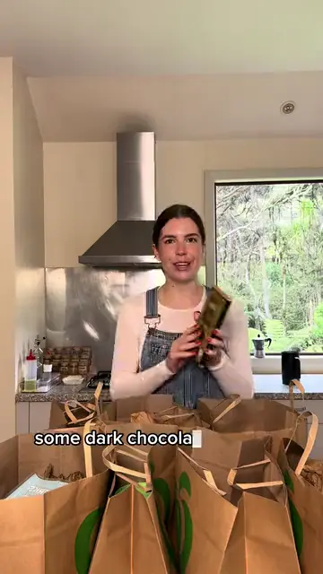 A woman unpacking paper grocery bags in her kitchen