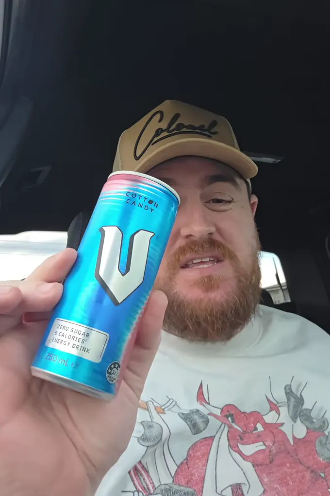 Example post, a reel: a man in a cap sitting in his car holding up a can of energy drink