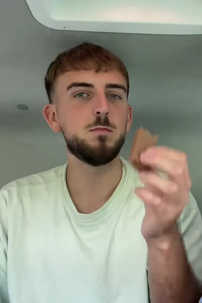 Example post, a story: a young man holding up a piece of chocolate biscuit